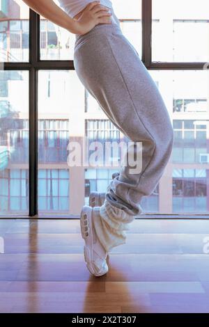 Ballerino con la mano sull'anca che fa la punta del piede in studio Foto Stock