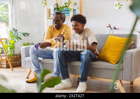 Un uomo anziano e un nipote si divertono a giocare a casa Foto Stock