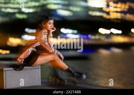 Donna premurosa seduta sulla panchina e a contemplare la notte Foto Stock