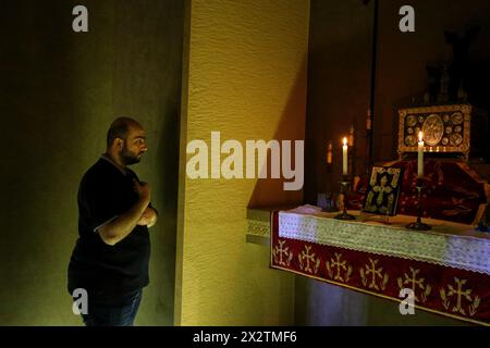 Beirut, Beirut, Libano. 23 aprile 2024. Un armeno libanese prega all'interno del cimitero degli armeni giustiziati dai turchi ottomani, durante un servizio commemorativo presso il Catholicosato della Chiesa armena di Cilicia a nord di Beirut alla vigilia del 109° anniversario del genocidio armeno che fu effettuato nel 1915-1917 dall'Impero Ottomano e dal suo partito al governo, il Comitato di Unione e progresso, durante la prima guerra mondiale Il 24 aprile segnerà il 109° anniversario del genocidio armeno, quando più di 1,5 milioni di armeni furono sistematicamente sterminati dai turchi ottomani, un evento che Foto Stock