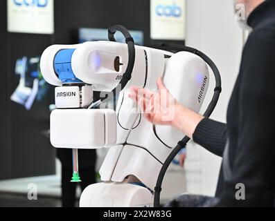 Hannover, Germania. 23 aprile 2024. Un visitatore interagisce con un robot alla Hannover Messe di Hannover, Germania, il 22 aprile 2024. La fiera Hannover Messe 2024, la fiera industriale leader in Germania, ha dato il via lunedì con una chiara enfasi sulla produzione a emissioni zero e sulle celle a combustibile a idrogeno. Crediti: Ren Pengfei/Xinhua/Alamy Live News Foto Stock