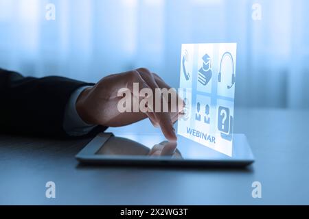 Webinar. Uomo che usa un tablet a tavola, primo piano. Schermo virtuale con icone sul computer Foto Stock