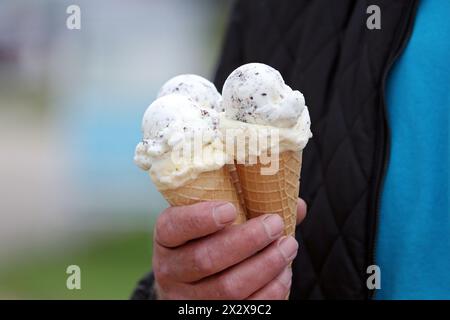01.09.2023, Iffezheim, Baden-Wuerttemberg, Germania - primo piano: L'uomo ha in mano tre coni di gelato. 00S230901D849CAROEX.JPG [MODELLO R Foto Stock