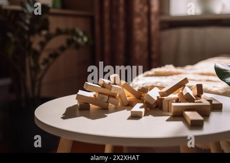 I blocchi di legno smontati dal gioco giacciono su un tavolo bianco Foto Stock