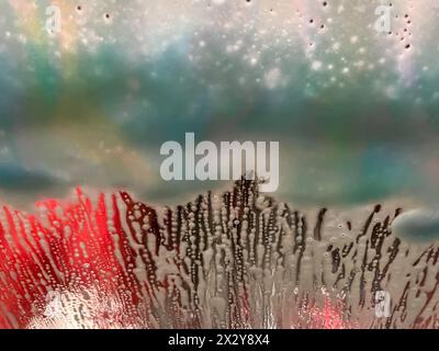 Sfondo astratto di sapone e acqua sul parabrezza di un veicolo in un autolavaggio automatizzato Foto Stock