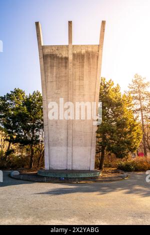 Il Memoriale degli ascensori di Berlino è immerso nel caldo bagliore dell'alba, con il terminal dell'aeroporto di Tempelhof sullo sfondo. Foto Stock