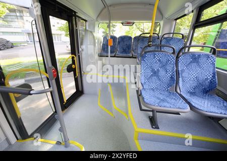 Posti a sedere nell'abitacolo di un autobus urbano vuoto con grandi finestrini. Foto Stock