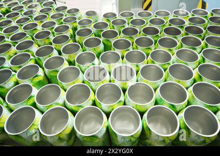 Molte lattine di alluminio aperte per bevande si spostano su un trasportatore in una fabbrica moderna. Foto Stock