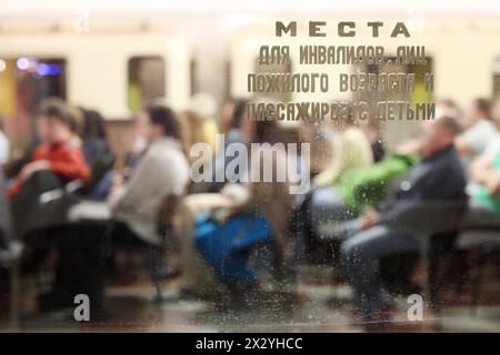 Vista dalla finestra della metropolitana su persone sedute in sedia a rotelle a Mosca, Russia. Attenzione alle iscrizioni in vetro - posti a sedere per disabili, anziani e persone con Foto Stock