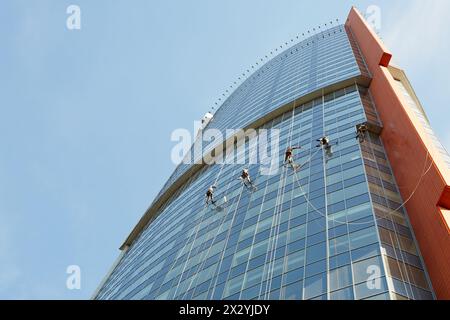 Gli addetti alla pulizia delle finestre lavorano su un alto edificio Foto Stock