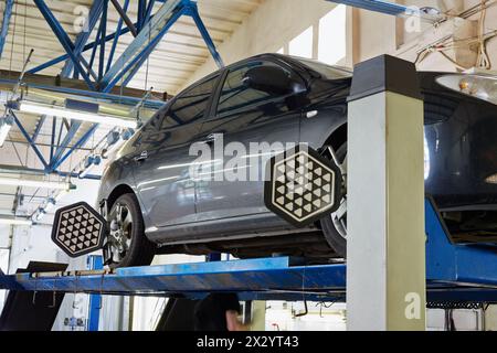 MOSCA - 22 agosto: Vettura sul banco con sensori sulle ruote per l'allineamento delle ruote controllo della campanatura nell'officina della stazione di servizio Avtostandart, 22 agosto 2012, M Foto Stock