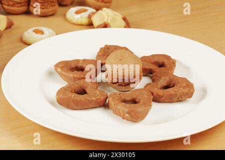 Piatto sul tavolo con biscotti e spugna a forma di fiore Foto Stock