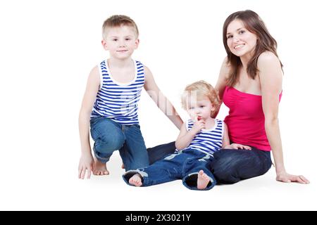 Madre e due figli in canottini a righe si siedono per terra Foto Stock