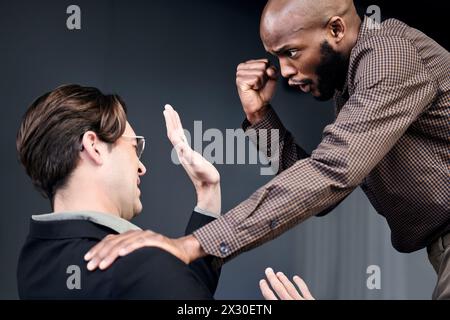 Arrabbiato, conflitto e lotta con gli uomini d'affari in studio su sfondo oscuro per disaccordo sul posto di lavoro. Responsabilità, pugno o stress e collega Foto Stock