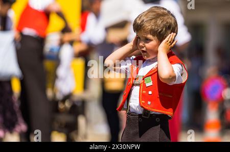 Ein kleiner Knabe in Appenzeller Tracht hält sich die Ohren zu. (Bad Zurzach, Schweiz, 12.06.2022) Foto Stock