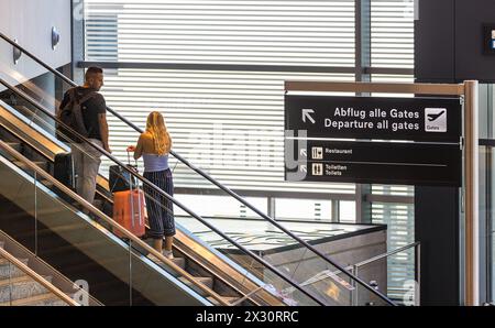 Zwei Reisende stehen auf der Rolltreppe in Richtung zu den Abflug Fluggaststeigen. (Zürich, Svizzera, 16.07.2022) Foto Stock