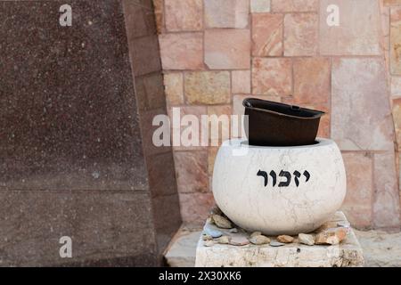 Un cartello di pietra che regge il casco di un vecchio soldato è inciso con la parola ebraica "ricorda" sul terreno del Monte Cimitero militare di Herzl a Je Foto Stock