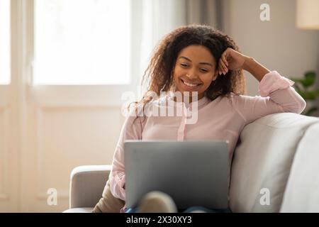 La giovane donna afroamericana ha rilassato il telelavoro Foto Stock