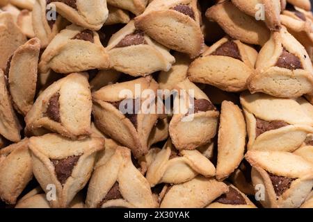 Hamantashen appena sfornato, biscotti triangolari ripieni di cioccolato o marmellata, tradizionalmente consumati dagli ebrei durante la celebrazione di Purim. Foto Stock