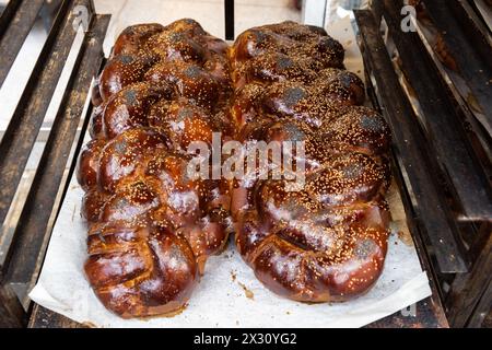 Grandi pani di Challah appena sfornati, intrecciati o pane all'uovo in vendita in una panetteria di Gerusalemme alla vigilia del sabato ebraico. Foto Stock