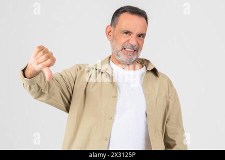 Uomo in camicia bianca e giacca Tan che mostra il pollice giù Foto Stock