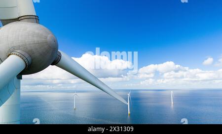 Una turbina eolica solitaria si erge in mezzo al vasto oceano, sfruttando la potenza del vento per creare energia pulita e rinnovabile per l'area circostante nei Paesi Bassi Noordoostpolder Foto Stock