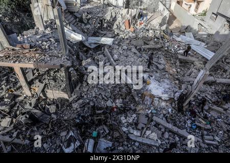 Rafah, territori palestinesi. 24 aprile 2024. I palestinesi ispezionano una casa che è stata distrutta dopo che un aereo israeliano ha bombardato una casa per la famiglia al-Bakhabsa, causando la morte di 3 persone e diversi feriti, nella città di Rafah, a sud della Striscia di Gaza. Crediti: Abed Rahim Khatib/dpa/Alamy Live News Foto Stock