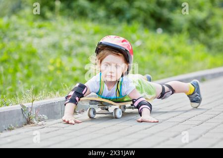 La bambina cavalca lo skateboard adagiato su di esso Foto Stock