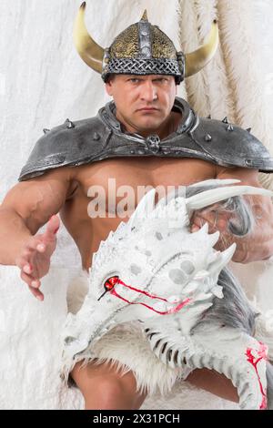 Un uomo muscoloso in costume vichingo con testa di drago Foto Stock