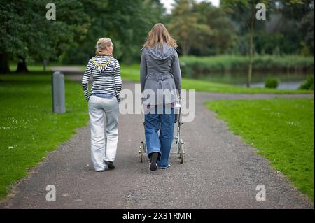 Due donne e un bambino due donne e un bambino all'interno di un puscart che parla e cammina alla Foresta di Kralingen durante un pomeriggio estivo. Rotterdam, Paesi Bassi. Rotterdam Vroesenpark Zuid-Holland Nederland Copyright: XGuidoxKoppesxPhotox Foto Stock