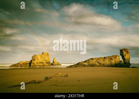 Alba sulla riva con rocce illuminate e arcobaleno, PlayOn de Bayas-Asturias, Spagna II Foto Stock