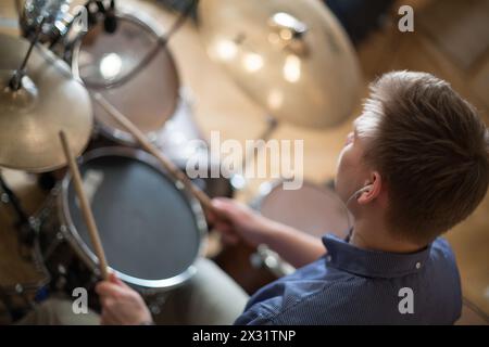 Il batterista con le cuffie suona il drum kit in studio Foto Stock