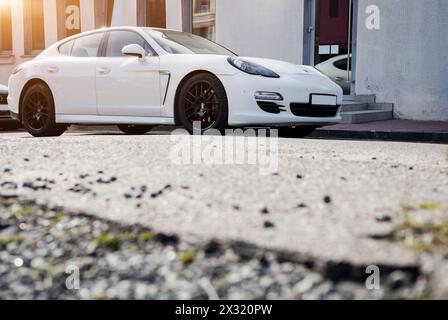 Minsk, Bielorussia, 24 aprile 2024 - Vista frontale Porsche Panamera tra splendidi edifici. Foto Stock