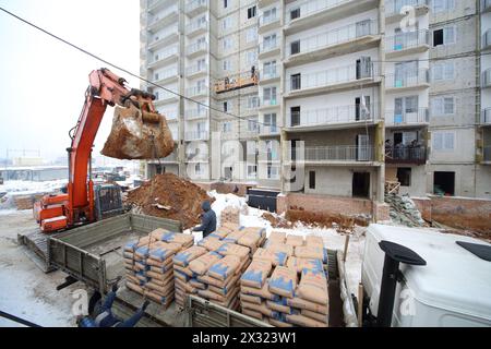 MOSCA - DEC 10: Scaricare il cemento da un camion alla costruzione della società NDV da un escavatore il 10 dicembre 2012 a Mosca in Russia. Foto Stock