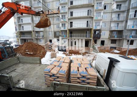MOSCA - DEC 10: L'escavatore scarica cemento da un camion per la costruzione della società NDV il 10 dicembre 2012 a Mosca in Russia. Foto Stock