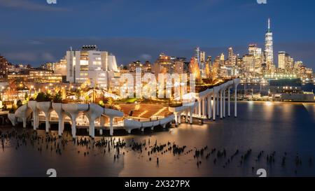 Serata al parco pubblico di Little Island con anfiteatro e vista del World Trade Center, New York. Hudson River Park (molo 55), West Village, Manhattan Foto Stock