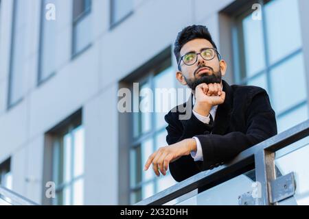 Stanco esausto uomo d'affari indiano che sbadiglia, sonnolento disattento, sonnolento pigro annoiato spalancato, che soffre di mancanza di sonno, che si addormenta all'aperto. Un libero professionista indù arabo nel centro città Foto Stock