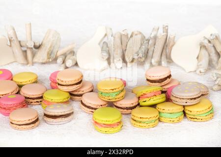 Stuzzicanti biscotti colorati con panna sul tavolo con uccello di legno Foto Stock