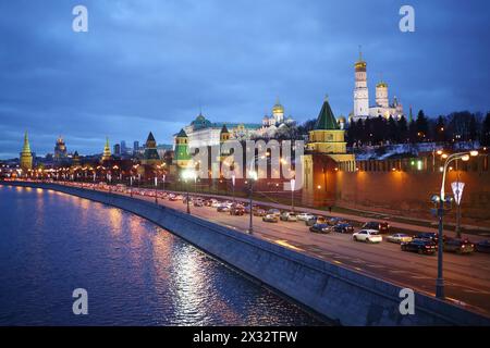 Traffico sul terrapieno del Cremlino contro il campanile di Ivan grande e il grande Palazzo del Cremlino in serata a Mosca, Russia Foto Stock