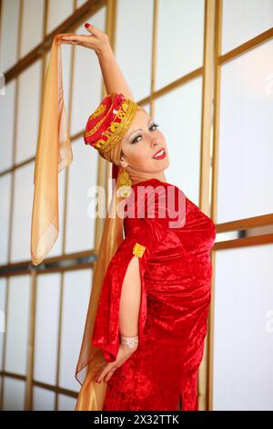 Giovane donna in costume andaluso rosso posa con scialli Foto Stock