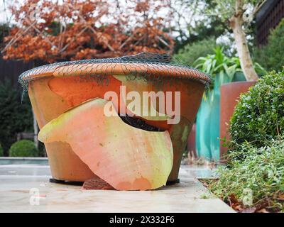 Il gelo ha rotto un grande vaso di piante da giardino in terracotta che è stato danneggiato durante un inverno freddo Foto Stock