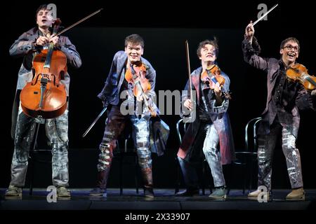 MOSCA - 12 marzo 2014: Quattro allegri uomini spettacolo di taper: Ballare sugli archi in costumi con strumenti musicali sul palco del Palazzo di Yauza Foto Stock