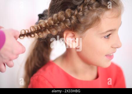 Ritratto di una ragazza la cui lunga treccia treccia, primo piano Foto Stock