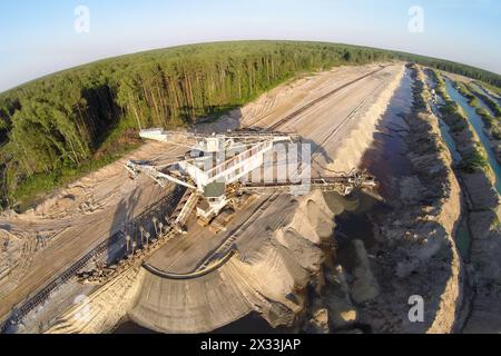 RUSSIA, VOSKRESENSK – 1 luglio, 2014: Absetzer Takraf al sandpit vicino alla foresta durante il tramonto. Vista aerea. Foto con rumore proveniente dalla Action camera. Foto Stock