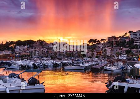 Port de Soller al tramonto. Il crepuscolo risplende di nuvole piovose. Porto con barche a destinazione di viaggio a Maiorca, Spagna Foto Stock