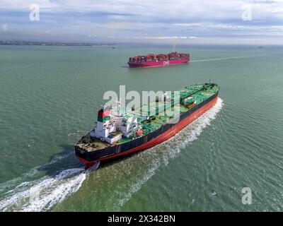 Vista aerea di un VLCC (Very Large Crude Carrier) che passa davanti a un VLCC (Ultra Large Container Carrier), entrambe parti importanti della catena di approvvigionamento globale. Foto Stock