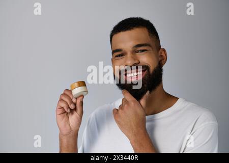 Un uomo barbuto che regge un barattolo di panna. Foto Stock