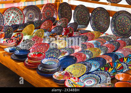 Piatti e ciotole uzbeke fatti a mano con motivi tradizionali colorati sono messi in vendita in un mercato di strada a Bukhara Foto Stock