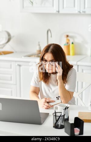 Donna di mezza età che lavora al tavolo con un notebook. Foto Stock