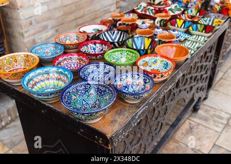 Un assortimento di ciotole uzbeke fatte a mano con motivi tradizionali colorati sono messe in vendita in un mercato di strada a Bukhara Foto Stock